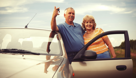 two older couple outside their car